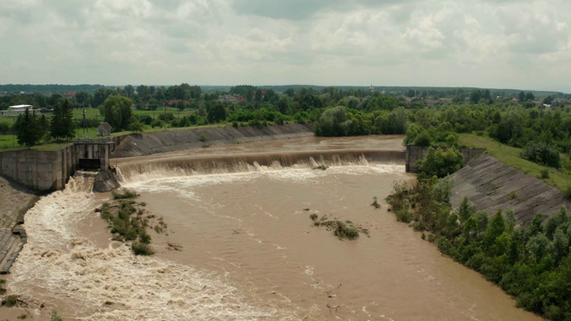 空中无人机视图。洪水和暴雨过后，河水随着充满水的堤坝向下流动。广角镜头V2视频素材