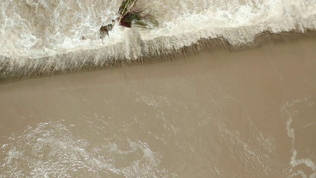 空中无人机视图。洪水和暴雨过后，河水随着充满水的堤坝向下流动。关闭水视频素材