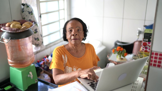 高级女性在家使用笔记本电脑的肖像视频素材