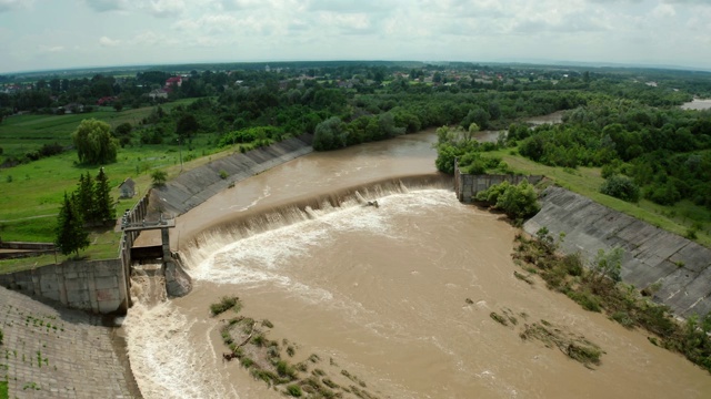 空中无人机视图。洪水和暴雨过后，河水随着充满水的堤坝向下流动。广角镜头V4视频素材
