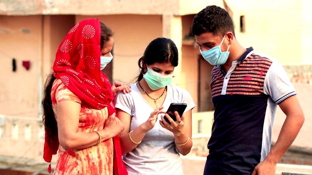 家庭用污染口罩覆盖脸部，以防止病毒和所有使用手机在家里一起视频素材