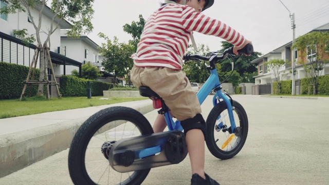 孩子们在街上骑着平衡自行车。视频素材