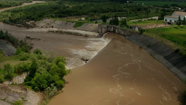 空中无人机视图。洪水和暴雨过后，河水随着充满水的堤坝向下流动。V5视频素材