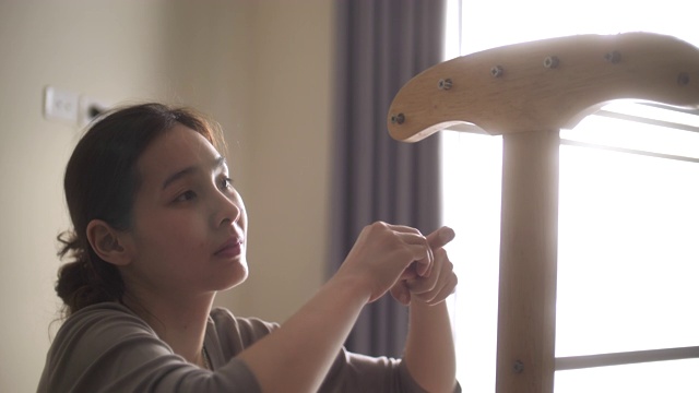 亚洲妇女在家里组装家具视频素材