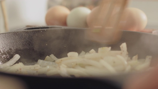 用木勺在平底锅中搅拌洋葱视频下载