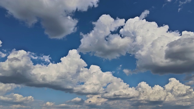 在纯净的白天，在湛蓝的天空中，通过美丽的蓬松的白云慢慢移动的柔软的飞行时间。视频素材
