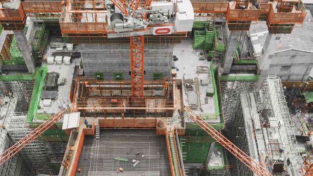 施工现场鸟瞰图4k时间间隔大型施工现场，包括几台起重机在一个建筑区域工作缩放视图视频素材