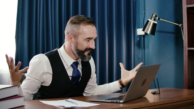 SLO mo:在办公室使用笔记本电脑庆祝成功的商人。视频素材