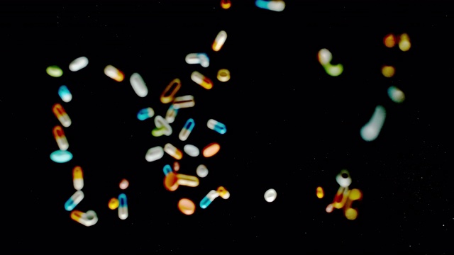 SLO MO LD的“饮食”题字由五颜六色的药片、药丸和胶囊飞向空中视频素材