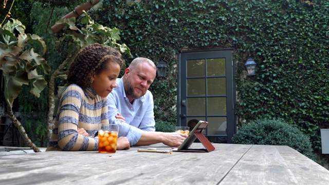 父亲和女儿一起在后院开发数字平板电脑视频下载
