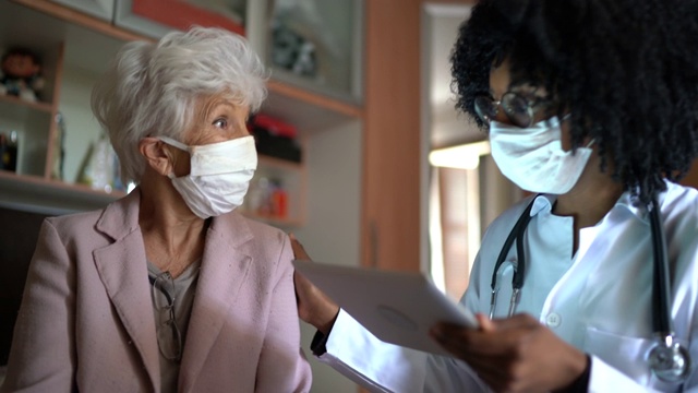 家访期间的健康访视员和一名老年妇女视频素材