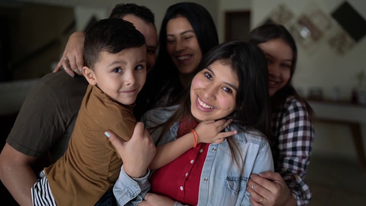 一个幸福的家庭在家里拥抱的肖像视频下载