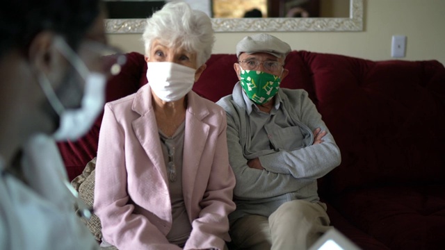 家访期间的健康访视员和一对老年夫妇视频素材