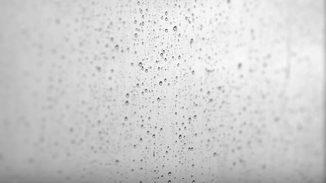 雨滴从窗户上流下的微距摄影。窗外的雨视频素材