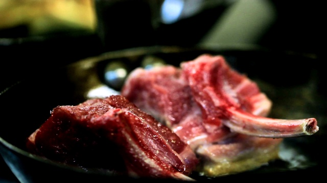 一个厨师在一个煎锅里烹饪肉，烹饪由一个厨师在一个餐馆-近距离视频下载