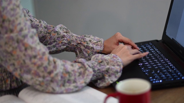 一位亚裔中国美女在家工作，作为客户服务，用厨房里的笔记本电脑在线回答客户的问题视频素材