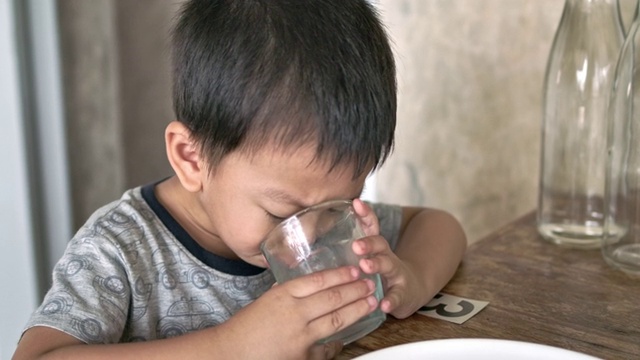 男孩从杯子里喝水视频素材
