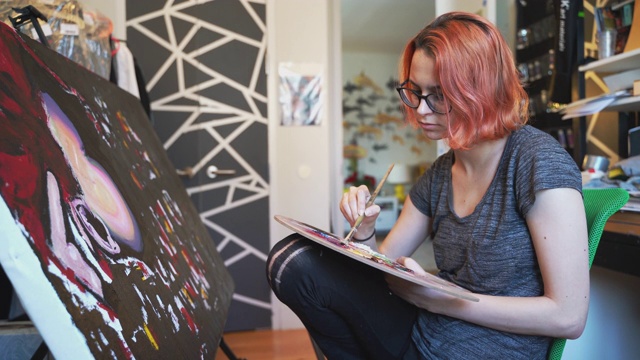 红发白人少女，艺术家，在她的房间里用油画颜料作画。视频素材