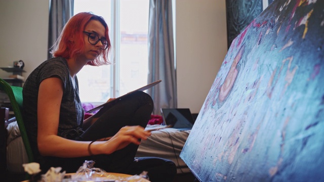 红发白人少女，艺术家，在她的房间里用油画颜料作画。视频素材