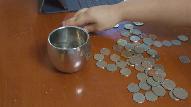一个小女孩正在收集罐里的硬币视频素材