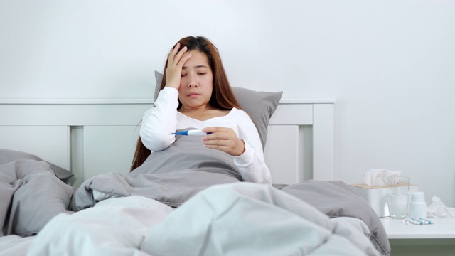 一名年轻亚洲女子患流感在家卧病的4K视频片段视频素材