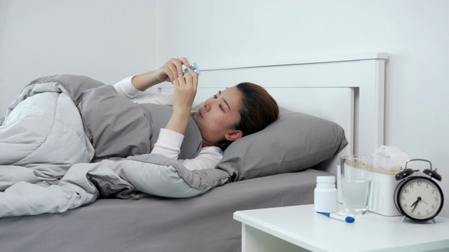 一名年轻亚洲女子患流感在家卧病的4K视频片段视频素材