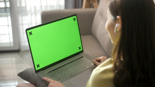 使用绿色屏幕笔记本电脑的女人视频素材