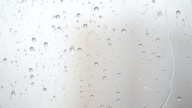 雨滴从窗户上流下的微距摄影。窗外的雨视频素材