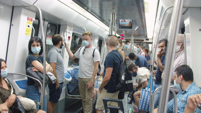 2019冠状病毒病期间，巴塞罗那地铁列车内部佩戴防护口罩的人员视频素材