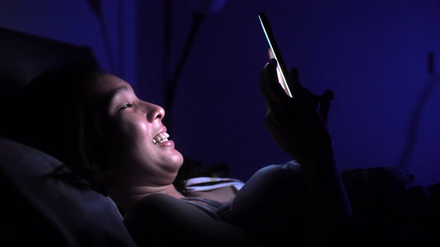 亚洲女性晚上睡觉前使用智能手机视频素材