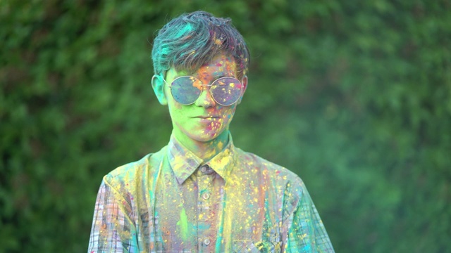在胡里节，男孩站在被彩色粉末覆盖的肖像。视频下载
