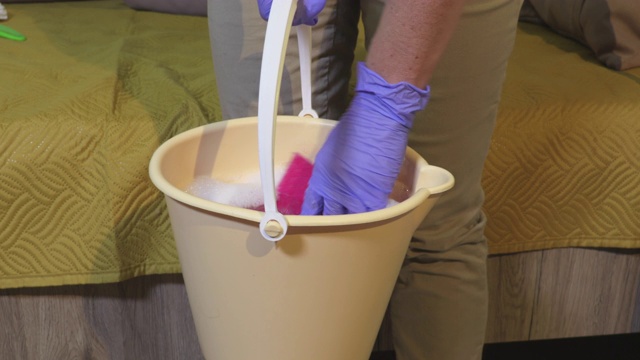 拿着水桶，挤着湿抹布的女人。清洁、家务和家政概念视频下载