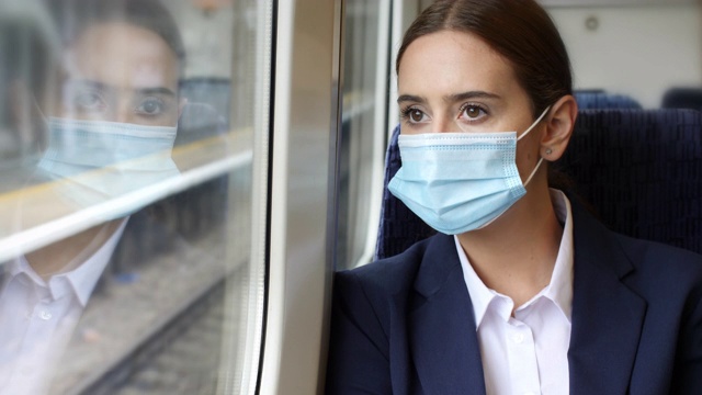 火车上戴的防护面罩。年轻女子在旅途中。视频下载