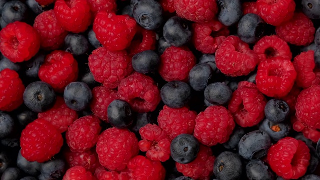 浆果旋转背景。健康饮食，素食，饮食。树莓，黑莓，蓝莓特写视频素材