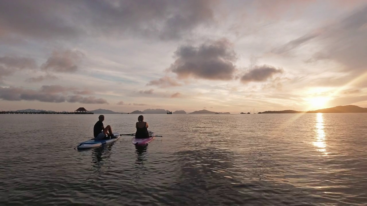 女孩朋友看美丽的日落从冲浪板在海上热带度假视频下载