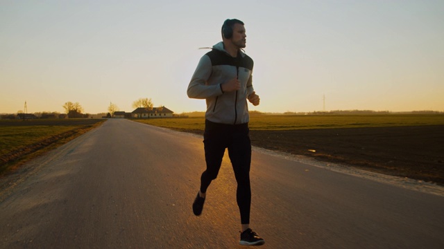 日落时分，一名男子在公路上慢跑视频素材