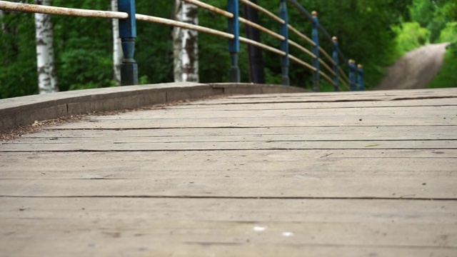 一个女孩在公园里的一座木桥上蹦蹦跳跳视频下载