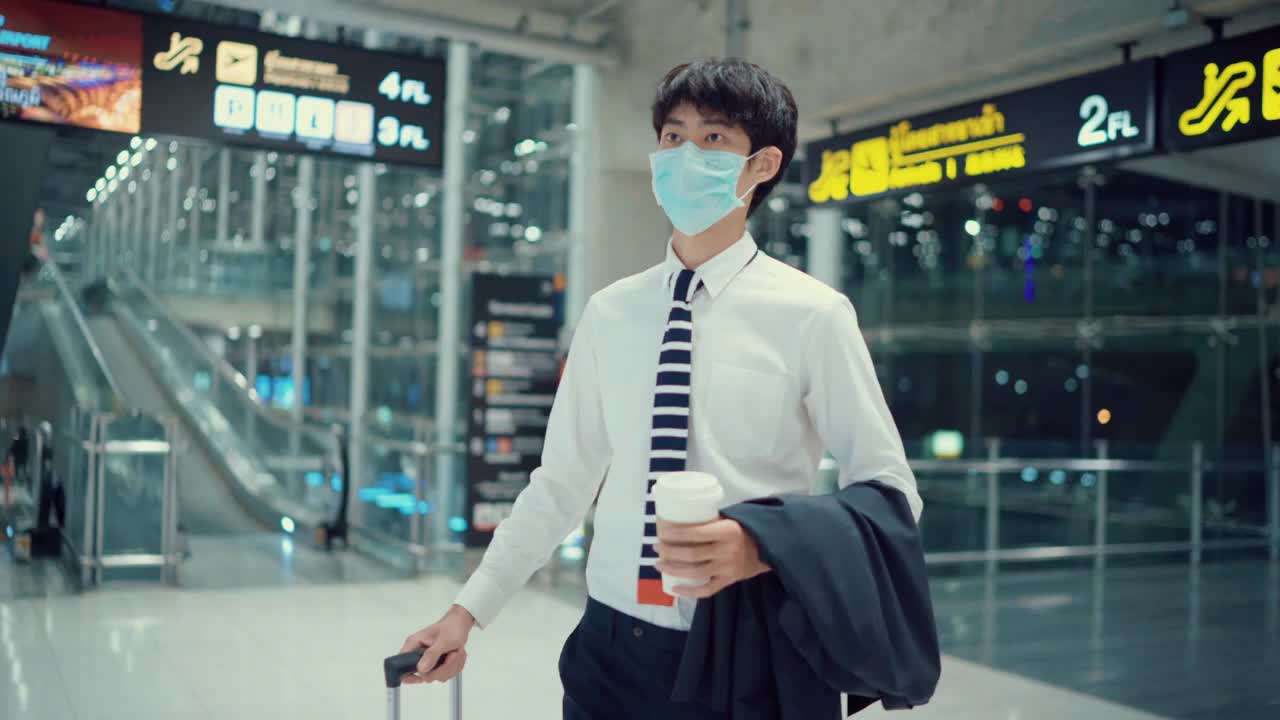 一名年轻的亚洲男子在机场用智能手机查看登机牌视频下载