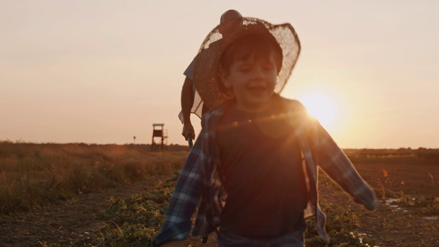 日落时分，父亲和儿子在田野里玩耍视频素材