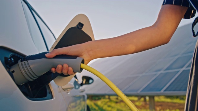 SLO MO女子用太阳能为她的电动汽车充电视频素材