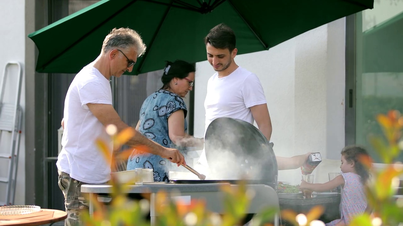 一家人在后院烧烤，父子俩在后院烧烤视频素材