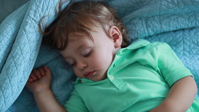 婴儿安静地躺在床上睡觉。婴儿睡着了。蹒跚学步的孩子打盹视频素材