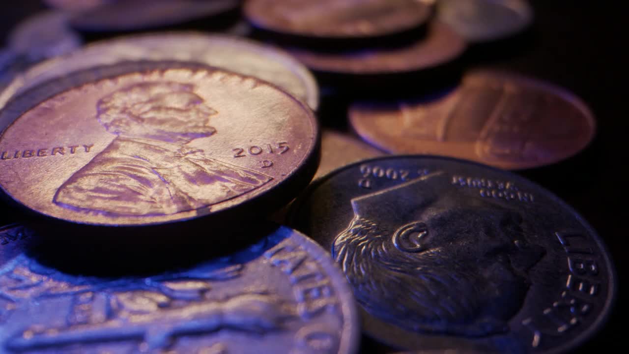 极端特写微距移动滑块拍摄堆积在木桌上的美国货币硬币视频素材