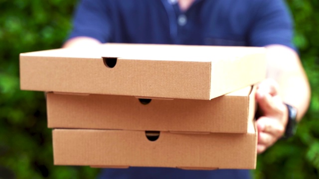 送披萨的男孩拿着披萨盒子在家门口的花园视频素材