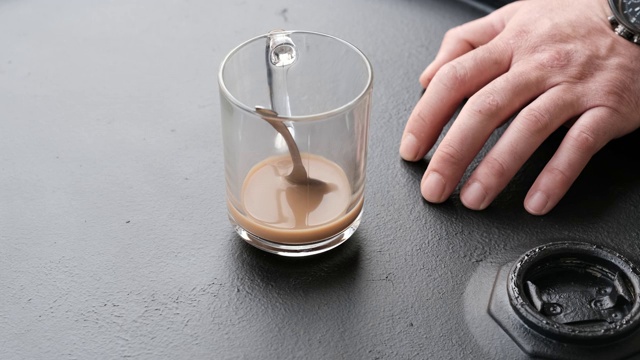 男性在黑色金属桶咖啡桌上喝咖啡视频下载