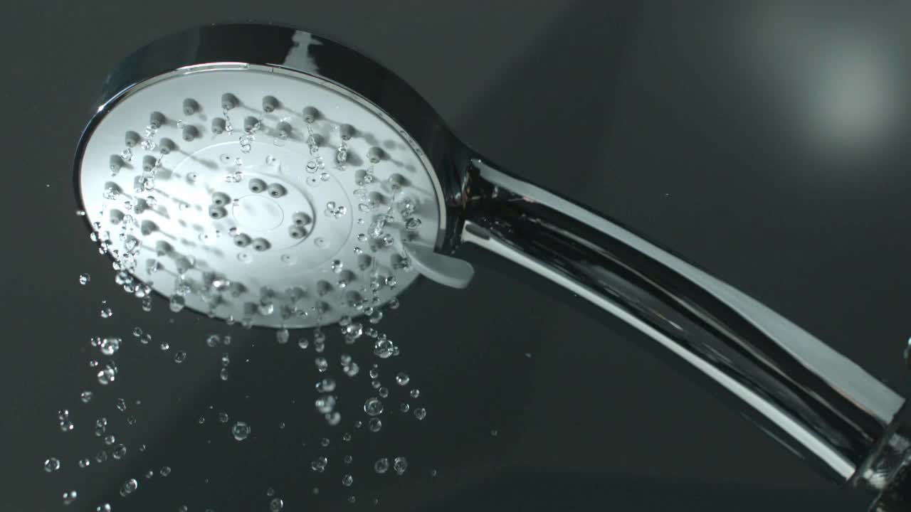 关闭淋浴头与水滴溅出和运行从浴室的水龙头流动在慢动作4K视频素材
