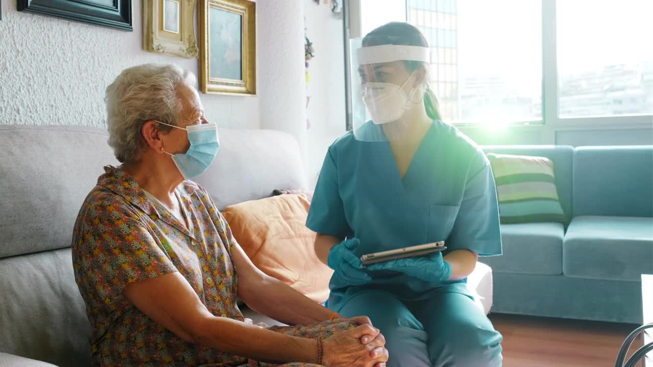 一位护士安慰一位老太太，并做了一项新冠肺炎调查。视频下载