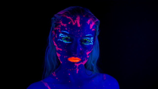 年轻的女人，在紫外线下，有着明亮的妆容视频下载