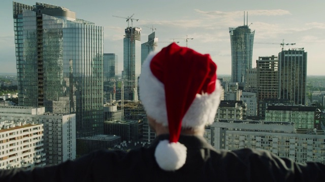 屋顶上戴圣诞帽的男人。圣诞节的气氛视频下载