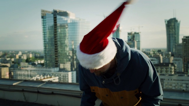 屋顶上戴圣诞帽的男人。疯狂的舞蹈，旋转的视频效果视频下载